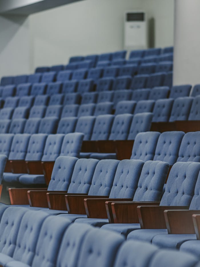 pexels photo 29572233 Blue upholstered chairs in an empty conference room, set for an event.