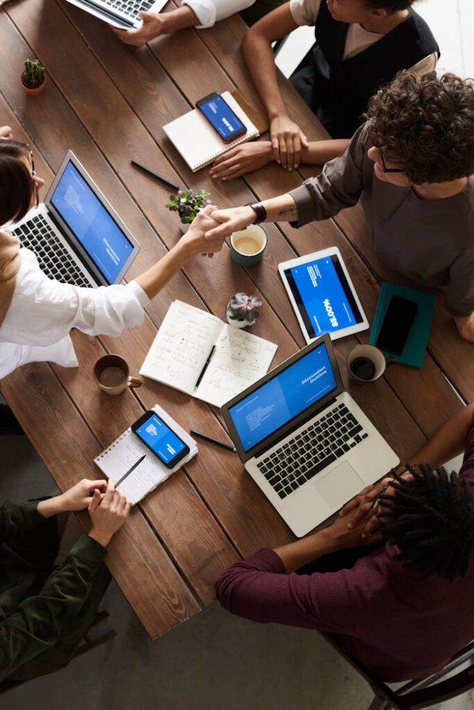 pexels photo 3183148 A diverse group of professionals brainstorming in a modern workspace with laptops and notebooks.